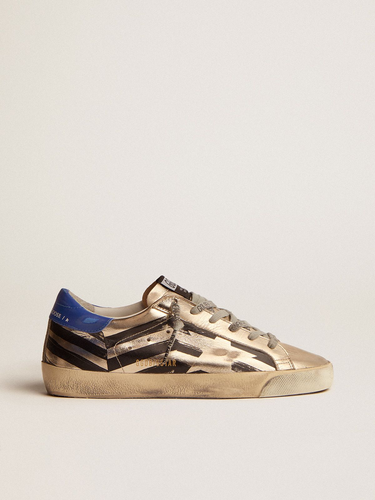 Sup-S sneakers in platinum-colored laminated leather with black flag print and red and blue heel tab