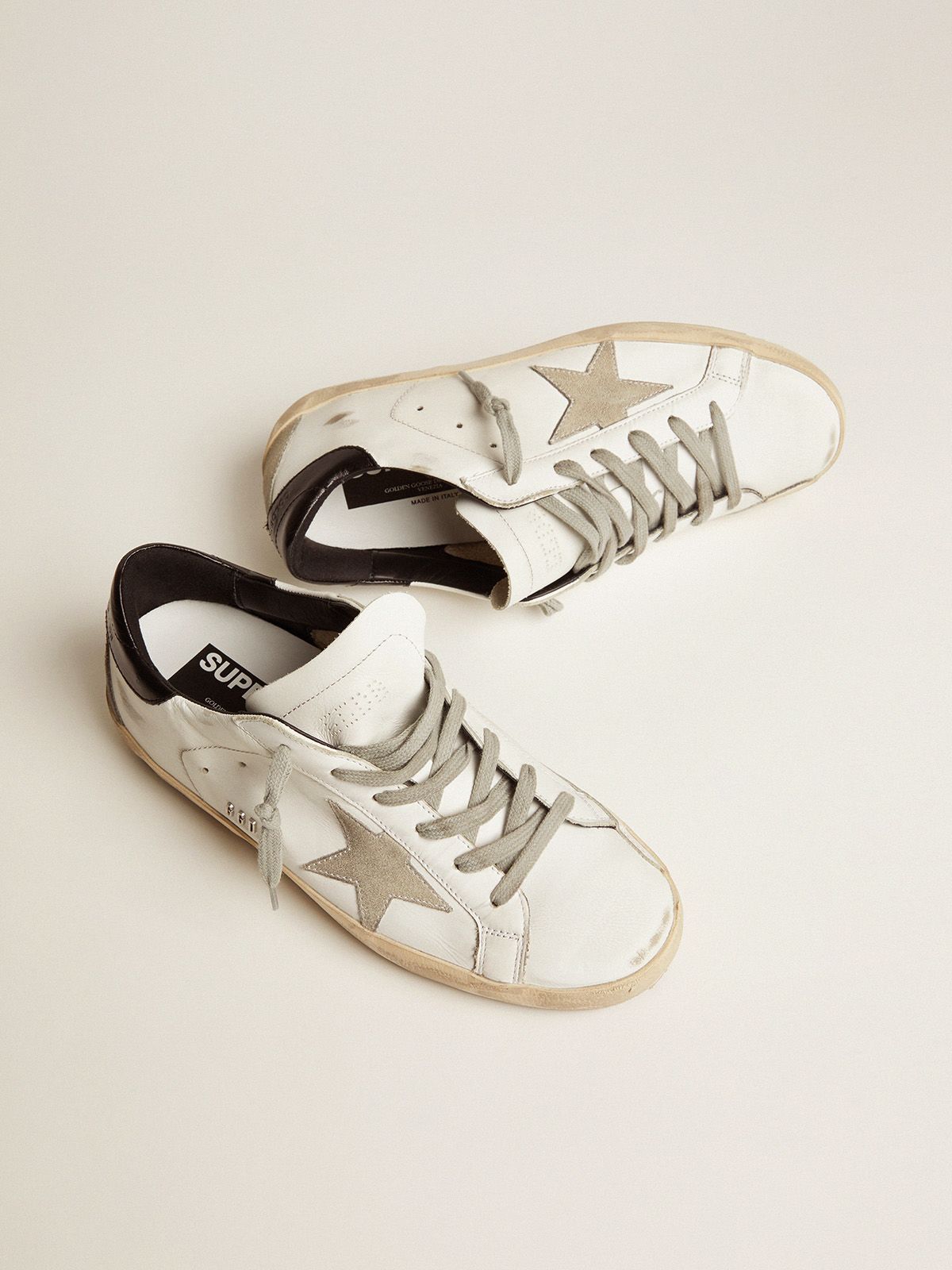 Sup-S sneakers with black heel tab and metal stud lettering